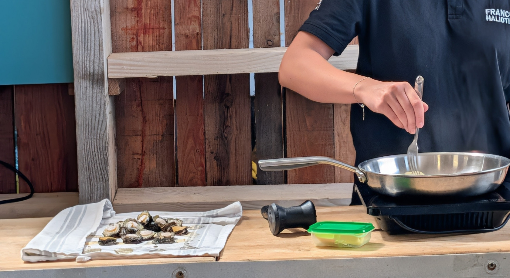 Une employée de France Haliotis en pleine préparation des ormeaux pour les participants. Crédit photo : Campus mondial de la mer